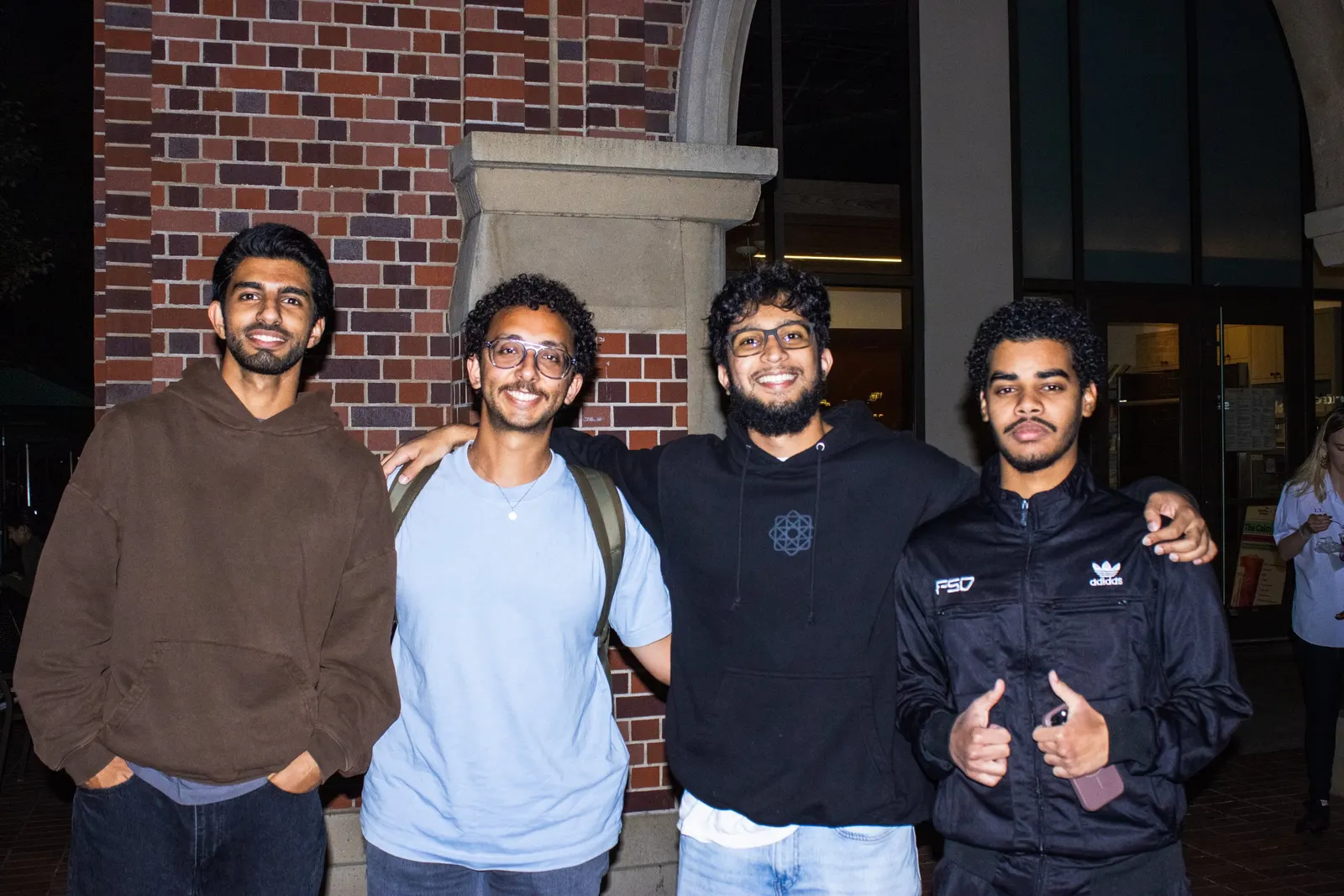 Four Trojan Street Aid members smiling together outside at night